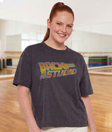 Dance teacher wearing a t-shirt with 'Back to the Studio' text in a dance studio setting