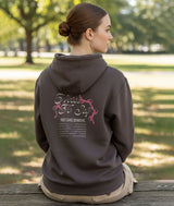 Dancer wearing a brown hoodie with "Daily Dance Reminders" on the back in a park setting