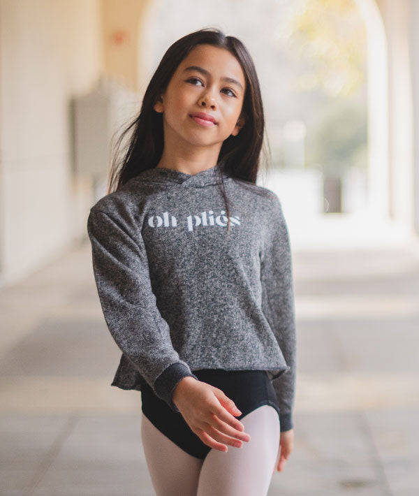 Young girl dancer wearing cropped hoodie from Covet Dance as a warm-ups