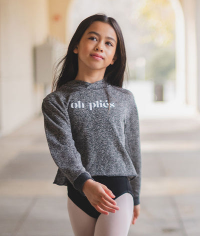 Young girl dancer wearing cropped hoodie from Covet Dance as a warm-ups