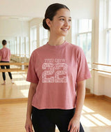 Dancer wearing a pink t-shirt with 'Tutu Crew 22' text in a dance studio.