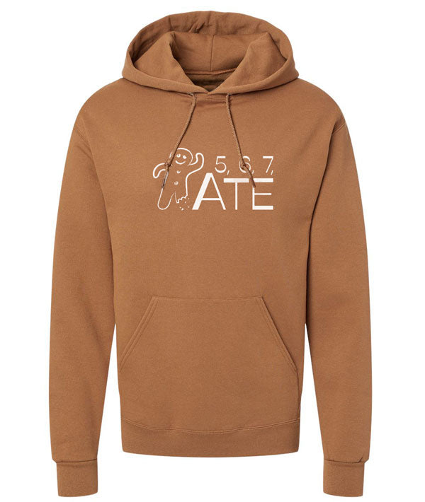 An orange brown hoodie featuring an illustrated gingerbread man and the text "5, 6, 7, ATE"