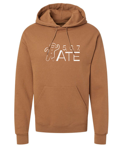 An orange brown hoodie featuring an illustrated gingerbread man and the text "5, 6, 7, ATE"
