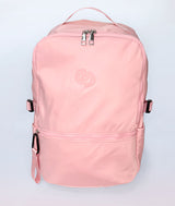 A light pink nylon Covet Dance backpack with a top handle, a top zipper with silver pulls, a front zippered pocket, and side buckle straps, shown against a plain light gray background.