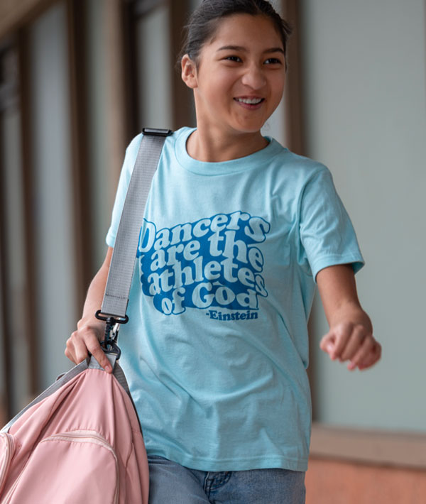 Dancer wearing Covet Dance "Athletes of God" tee running to class