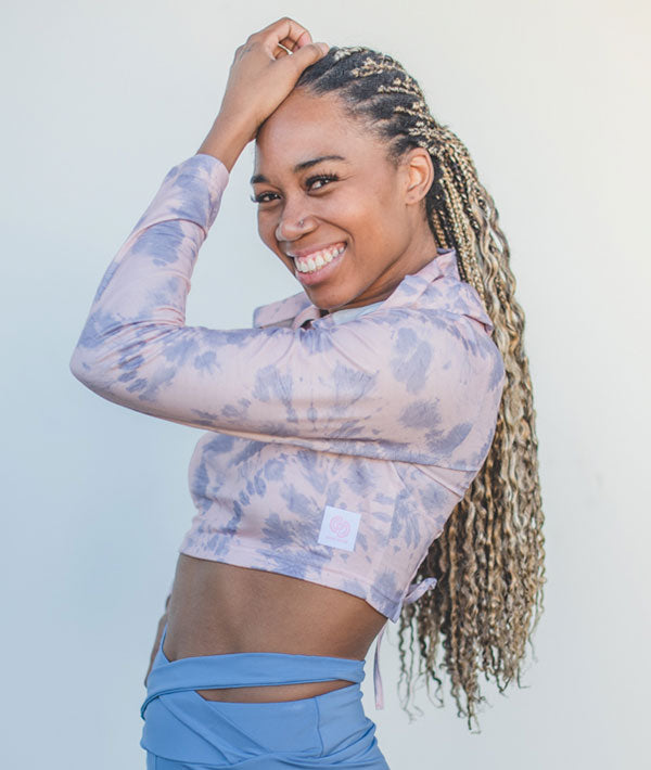 Dancer wearing marbled long sleeve crop top with blue criss-cross booty shorts