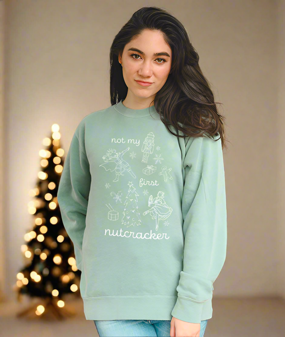 Dancer wearing Not My First Nutcracker crewneck at home with Christmas tree in background after ballet rehearsal