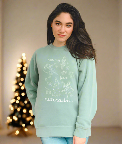Dancer wearing Not My First Nutcracker crewneck at home with Christmas tree in background after ballet rehearsal