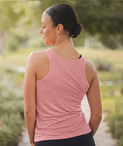 Back view of ballerina wearing a pink tank top in a natural setting