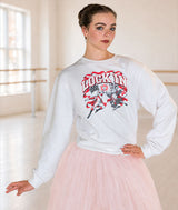 A dancer in a ballet studio wearing a white long-sleeve crewneck sweatshirt with a red and black 'LOCK IN" Nutcracker and Mouse King graphic, paired with a light pink tutu skirt.