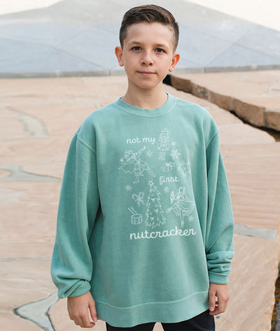 Young male Dancer wearing a light green sweatshirt with Not My First Nutcracker design from Covet Dance