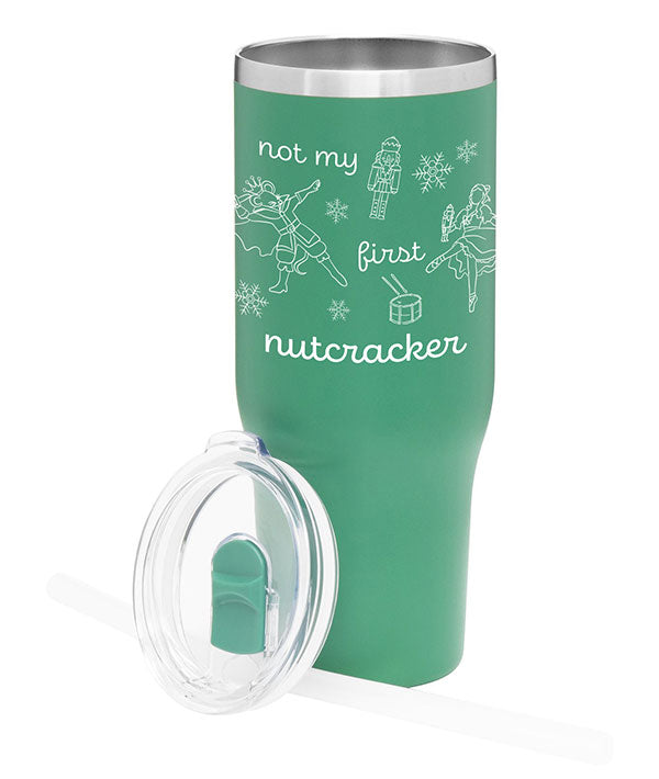 Green stainless steel tumbler with lid that says "Not my first nutcracker" in white print, with illustrations of the Nutcracker, Mouse King, Clara doing ballet in pointe shoes, and Christmas themed items: snowflakes and a drum.