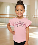 Young toddler girl in a ballet studio wearing a pink t-shirt with a kitty cat doing a Pas De Chat dance step