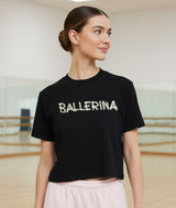 Dancer wearing a boxy black t-shirt with 'BALLERINA' text that looks like it was written with toe tape in a dance studio.