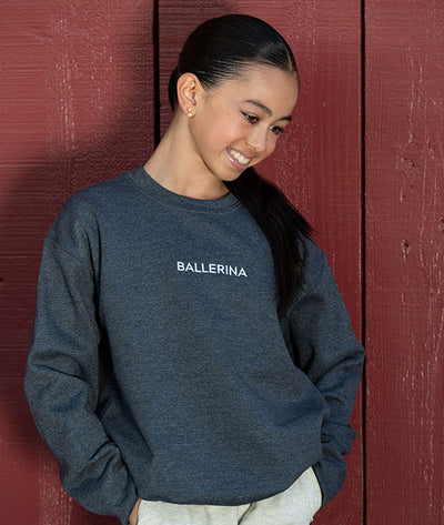 Young dancer wearing a heather gray sweatshirt with 'BALLERINA' embroidered in white