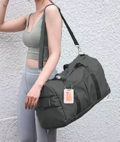 gray JOI bag with shoulder strap and aluminum tag