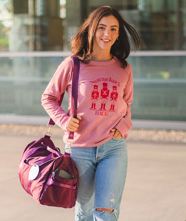 Dancer on her way to class wearing Nutcracker's Back Sweatshirt carrying dance bag