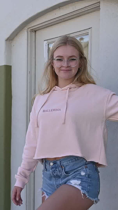 ballerina dancing in pointe shoes wearing cropped sweatshirt and glasses